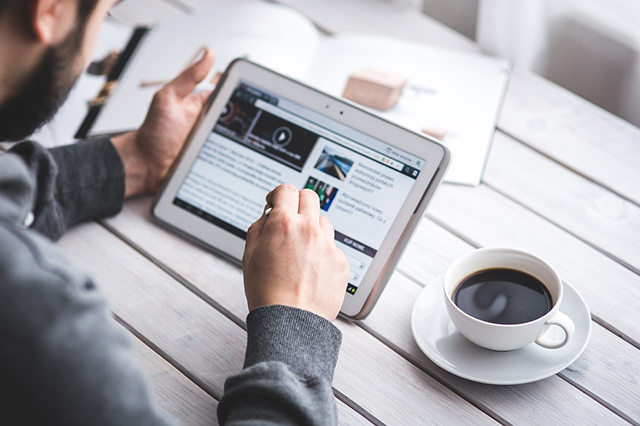 "Man reading on tablet"